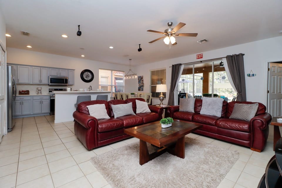 Gather in the open-plan lounge with comfortable leather sofas, flat-screen TV, and direct pool deck access – ideal for family relaxation.
