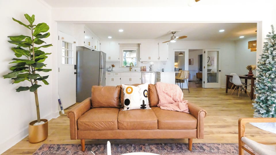 Cozy couch in front living room with open concept to full kitchen.