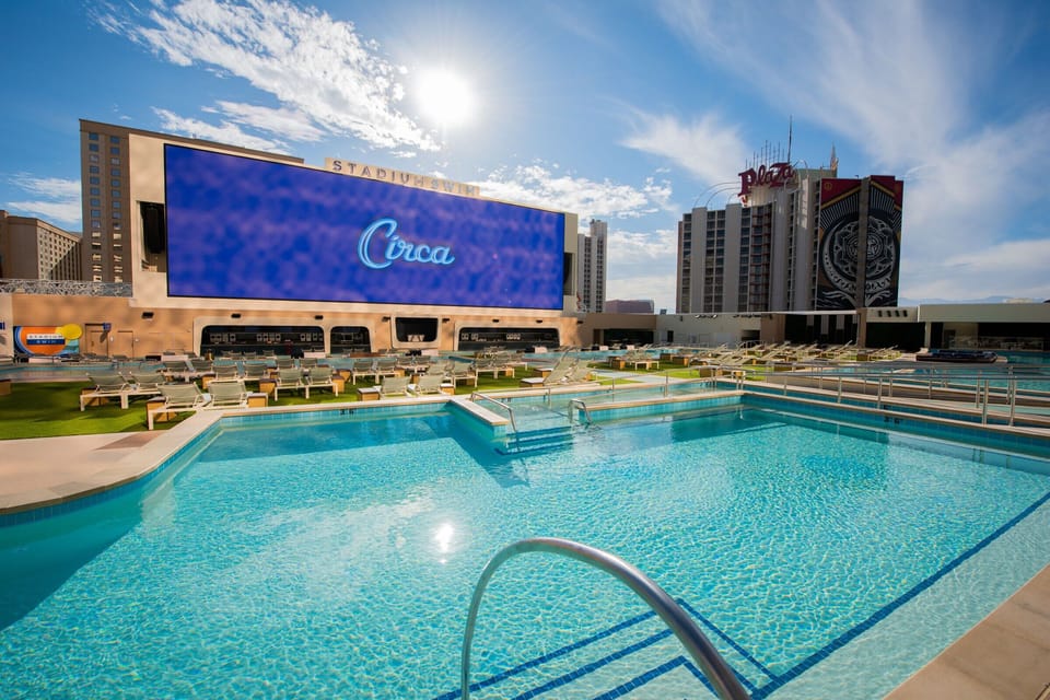 Dive into sunlit rooftop swimming with loungers and skyline views.
