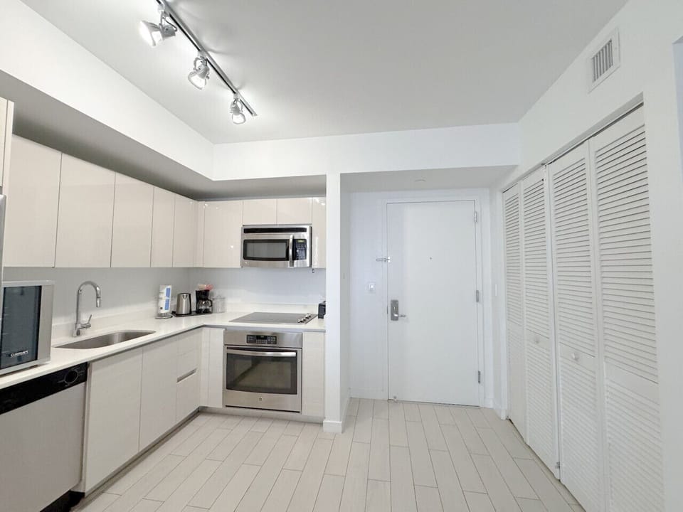Fully equipped kitchen with stainless steel appliances and a stylish backsplash.