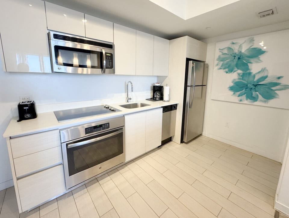 Fully equipped kitchen with stainless steel appliances and a stylish backsplash.