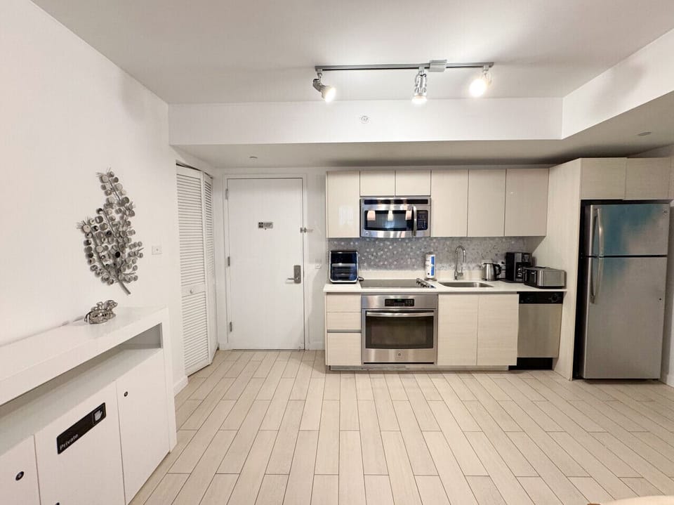 Fully equipped kitchen with stainless steel appliances and a stylish backsplash.