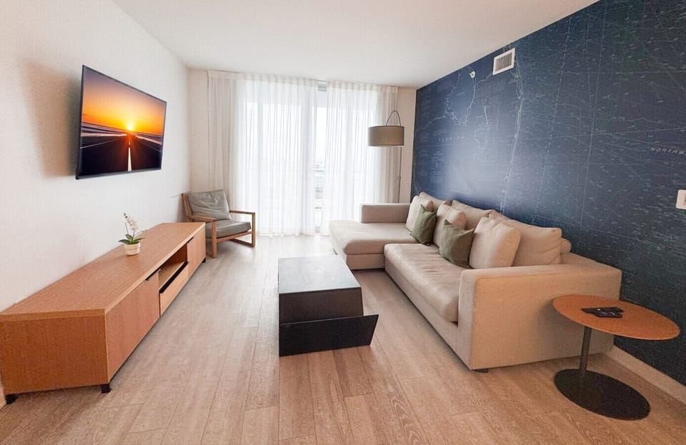 Bright living room with balcony access and city views.