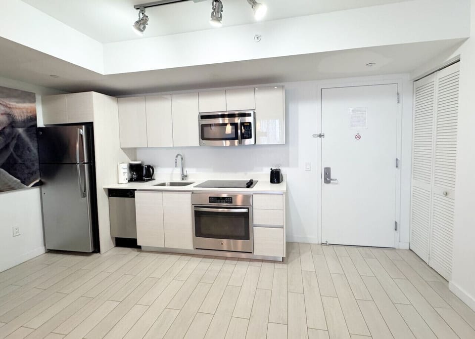Fully equipped kitchen with stainless steel appliances and a stylish backsplash.