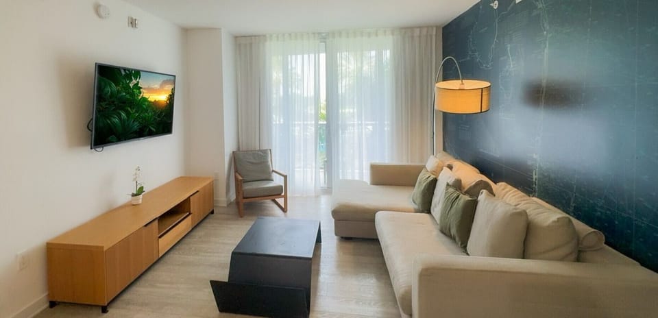 Bright living room with balcony access and city views.