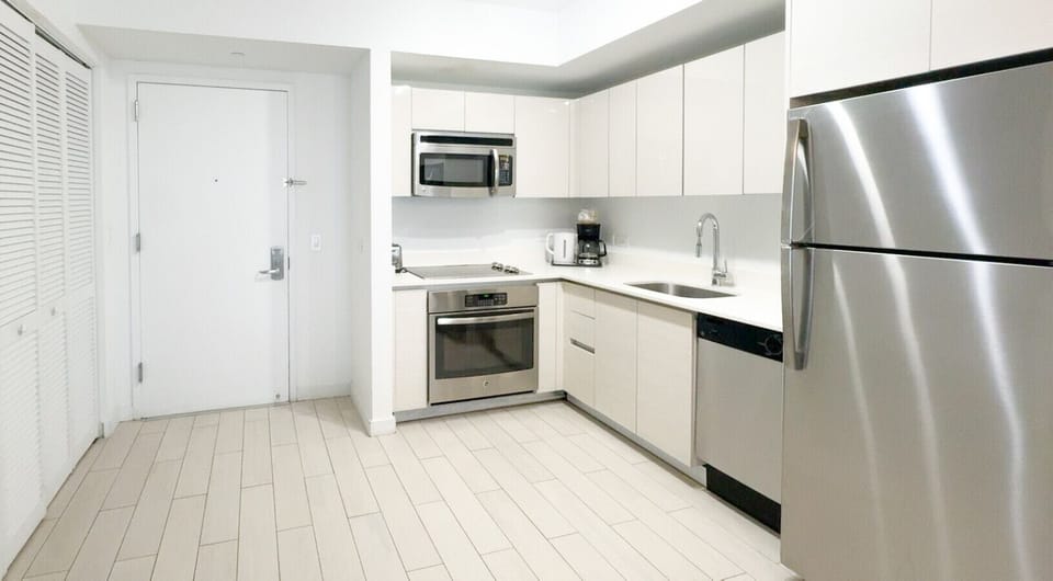 Fully equipped kitchen with stainless steel appliances and a stylish backsplash.