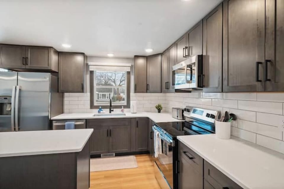 Cook With Confidence (Luxury + Practical) beautifully updated kitchen with sleek cabinets, high-end appliances, and ample counter space. Ideal for guests who enjoy cooking, entertaining, or simply relaxing in a comfortable, modern home near Lambeau.