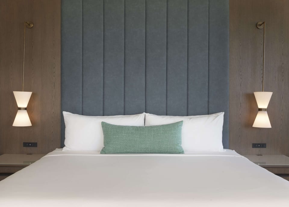 Sink into crisp linens beneath soothing, designer headboard lighting.