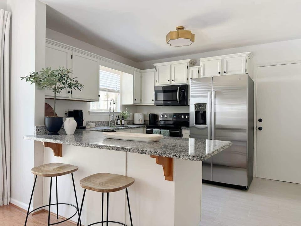 Light and airy - this roomy kitchen is packed with all the appliances and utensils you'd need to make any meal. Plus, guests can keep their chef company while seated at the breakfast bar. 