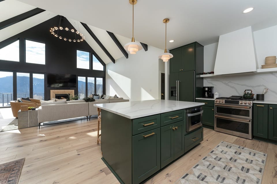 Luxury open floor plan with living, dining, and kitchen areas on the main level with floor-to-ceiling mountain views. Note: The fireplace is NOT usable.