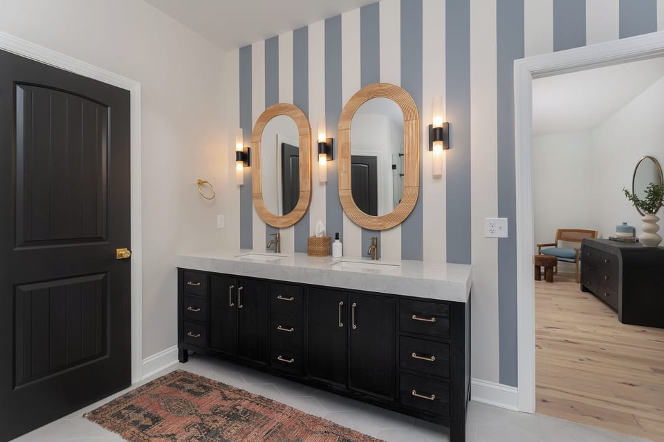 Main level en suite bath with walk-in closet, double vanity, walk-in shower, and separate toilet.
