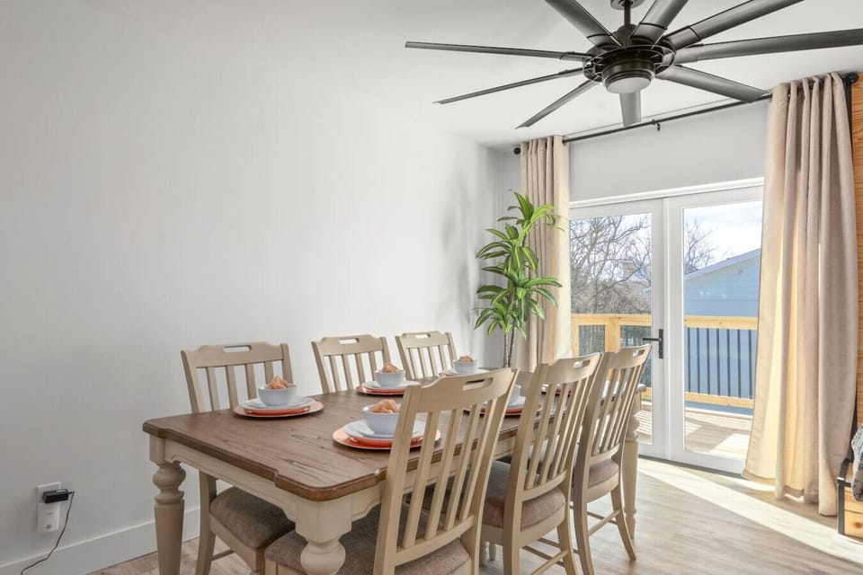 The bright dining room table invites cozy meals and lively conversations in one welcoming, sunlit space, with access to the wrap around porch.