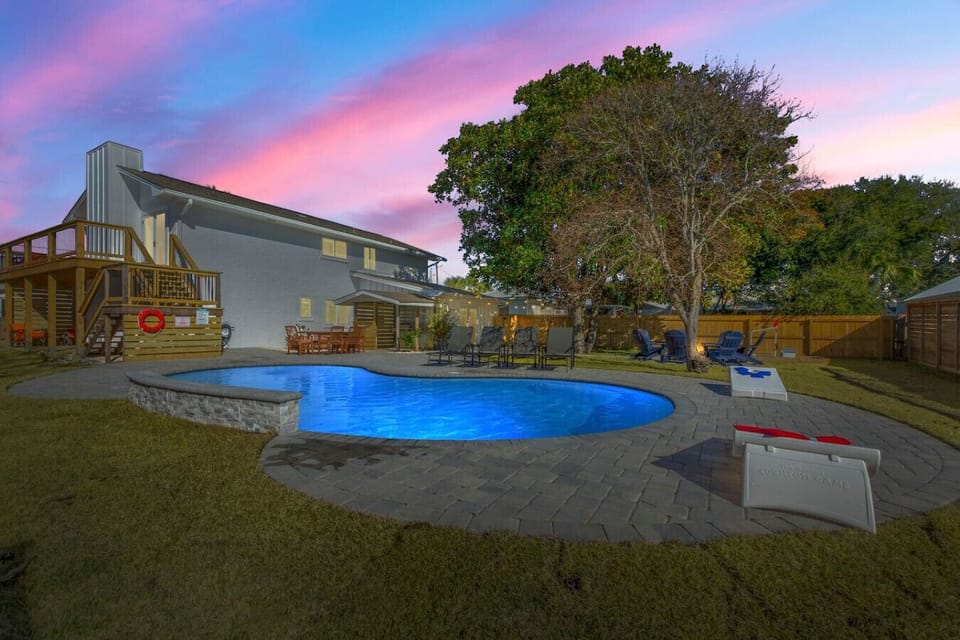 Enjoy a tranquil evening scene at the back of the house, where the softly illuminated pool creates a soothing backdrop for quiet relaxation under the stars.