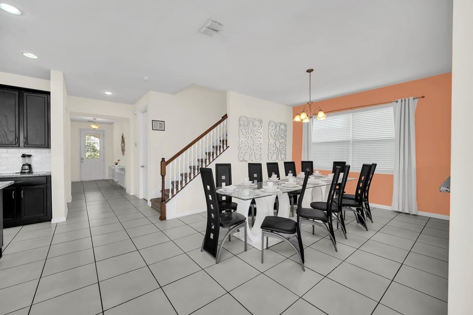 Spacious and welcoming dining area, complete with a modern glass-top table. The open layout and soft accent lighting create a perfect setting for family meals and lively gatherings.