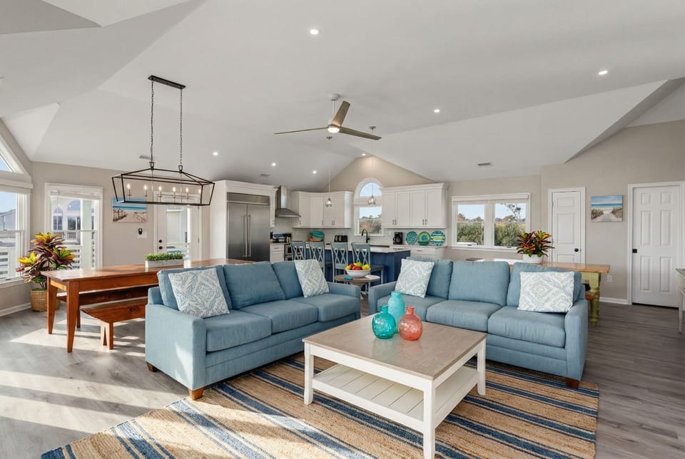 Expansive living area with plush seating, a pool table, and panoramic ocean views.