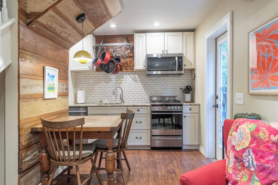 There are 2 dining chairs at the dining table with overhead lighting 