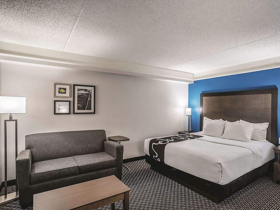 Unwind on crisp linens beside a cozy lounge area.