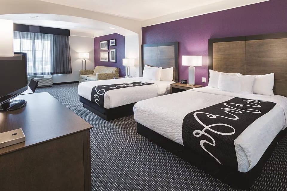 Unwind in a bright double-queen room with cozy seating.