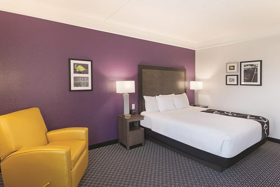 Recharge in a quiet corner room with soothing purple accents.