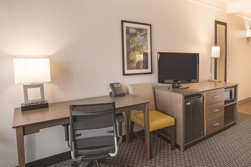 Get work done comfortably with desk, TV, and essentials.