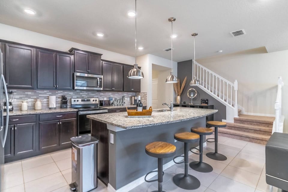 Updated and fully stocked Kitchen with Granite counters and stainless steel appliances and bar seating for 4