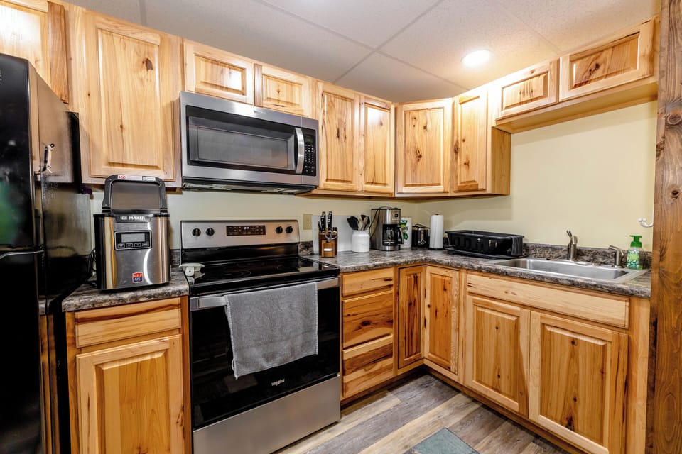 Fully equipped kitchen with stainless steel appliances, wooden cabinetry, and ample counter space.