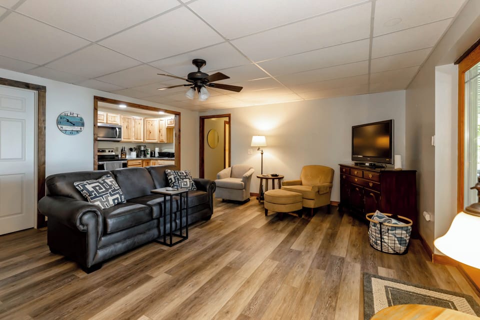 Inviting living room with plush seating, a flat-screen TV, and warm, ambient lighting.