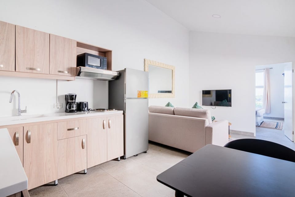 Prepare meals in a fully equipped kitchen with modern appliances at your convenience - Open plan living space provides a comfortable area to relax or watch TV - Thoughtfully designed layout makes dining and lounging feel effortless