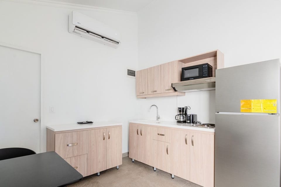 Compact yet fully equipped kitchen designed to meet all your cooking needs - Features modern appliances and plenty of storage for a seamless experience - Enjoy the convenience of preparing home cooked meals in a thoughtfully arranged space