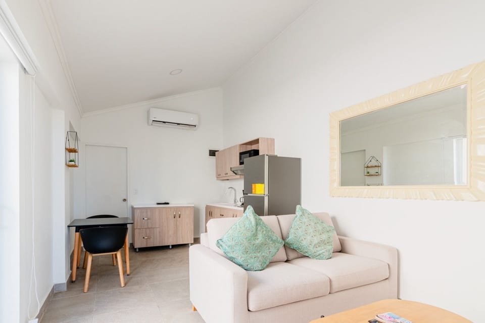 Relax on a cozy couch with vibrant accents that add a warm and inviting touch - Adjacent dining area provides the perfect spot for enjoying meals or remote work - Open, airy layout seamlessly enhances comfort, usability, and a welcoming vibe