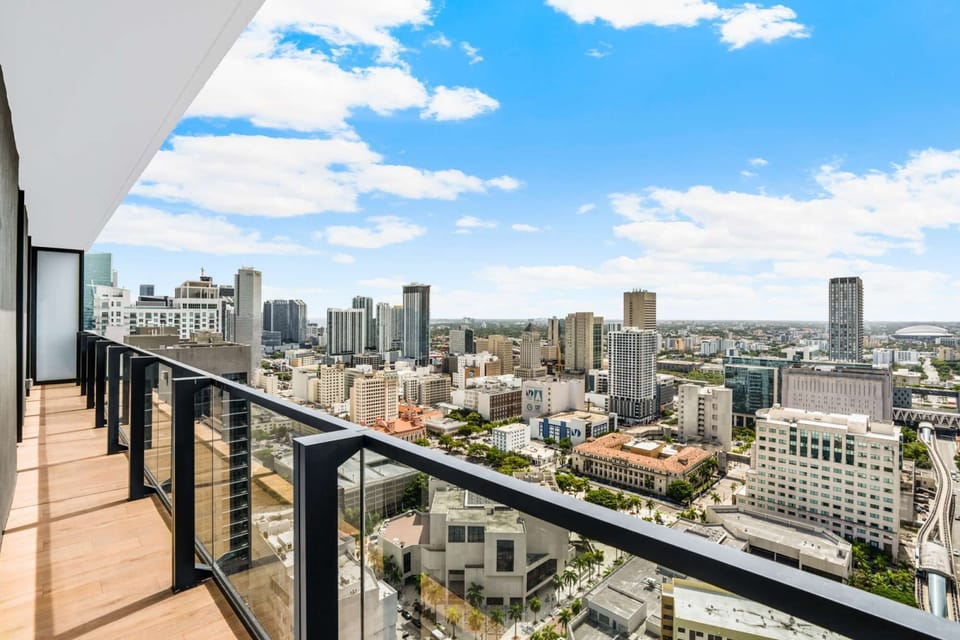 Spacious balcony with city skyline and clear skies.
