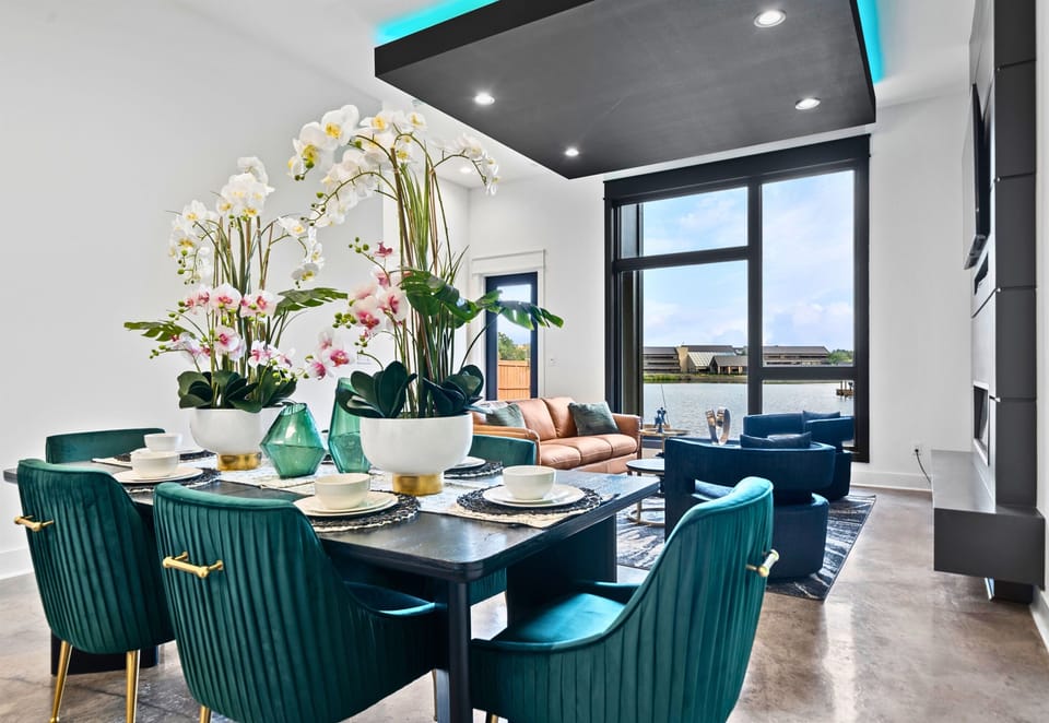 Gather around this vibrant dining area, complete with stylish seating, chic lighting, and large windows that flood the room with natural light for a welcoming ambiance.