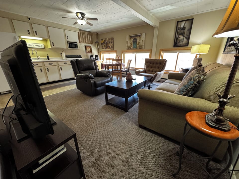 Open concept living and kitchen area with comfy seating and view of Main Street