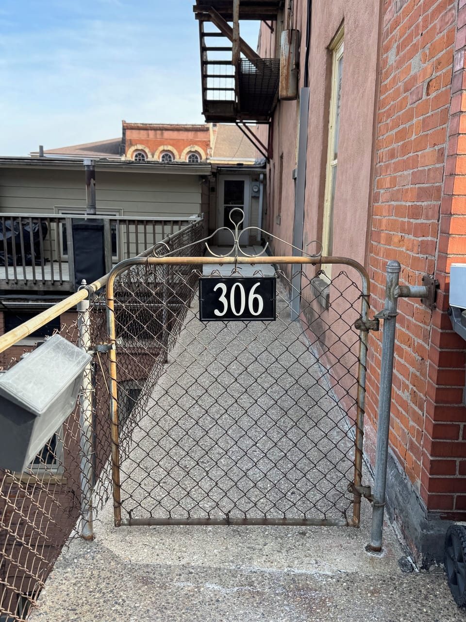 Address sign and gate to entrance of apartment.