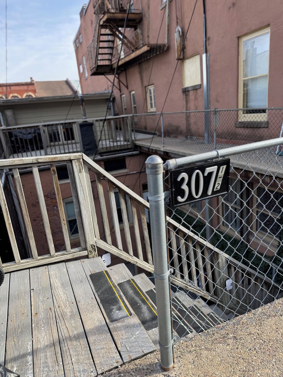 Address sign and entrance to stairs leading down to the apartment