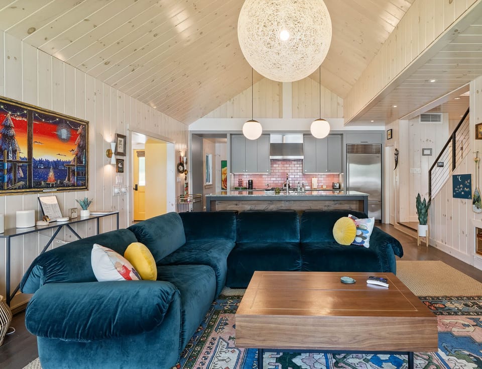 A bright, open living space with vaulted ceilings, comfortable seating, and easy flow into the kitchen, perfect for gathering and relaxing together.