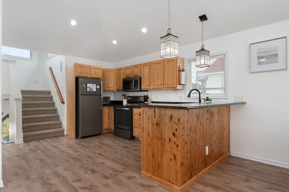 Well-appointed kitchen featuring granite countertops, upgraded appliances, and a breakfast bar, ideal for preparing home-cooked meals.