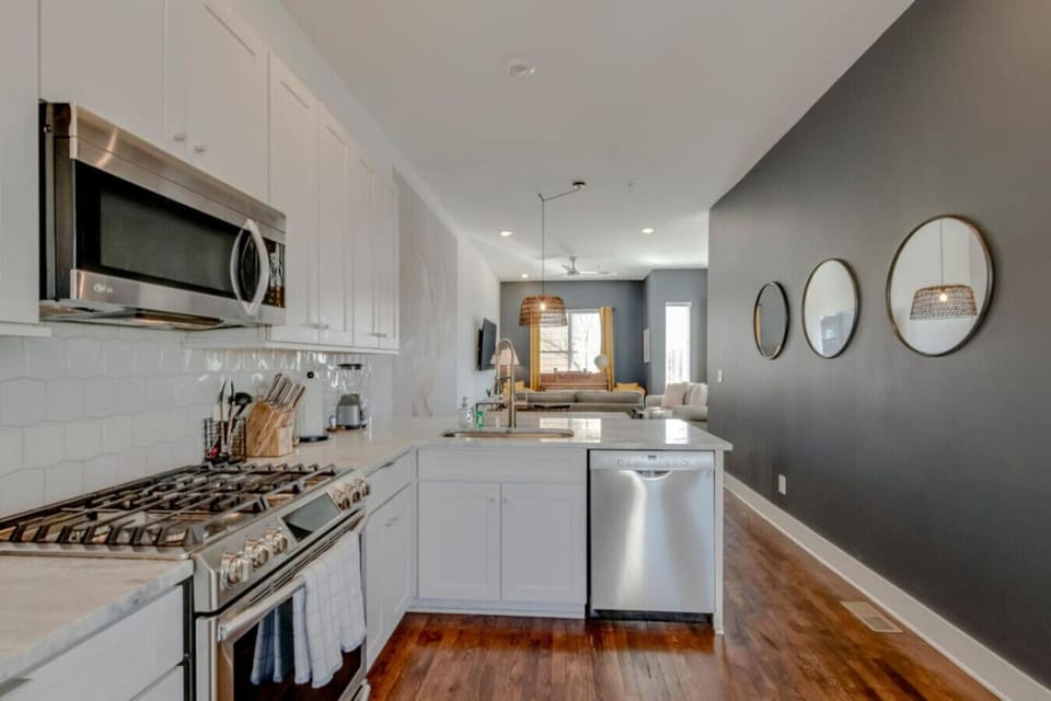 Kitchen from alternate angle showing dark accent wall, stainless range, and mirrors