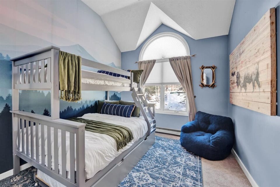 This third bedroom on the second floor features a bunk bed with a trundle, offering plenty of sleeping space for everyone