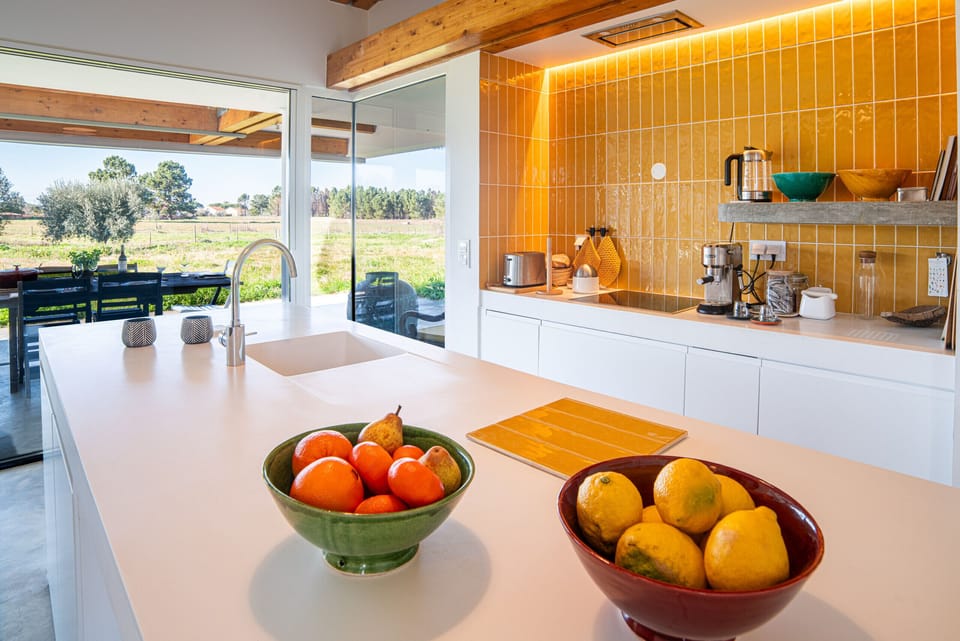 Modern kitchen with orange tile backsplash and countryside views — Villa do Pinheiro, luxury holiday villa in Grândola