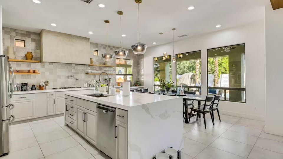 Gourmet kitchen equipped with  a waterfall island, and generous prep space.