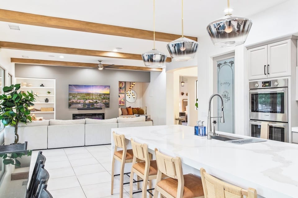 Sleek and modern kitchen featuring a large island with bar stools, ideal for cooking, dining, or socializing.