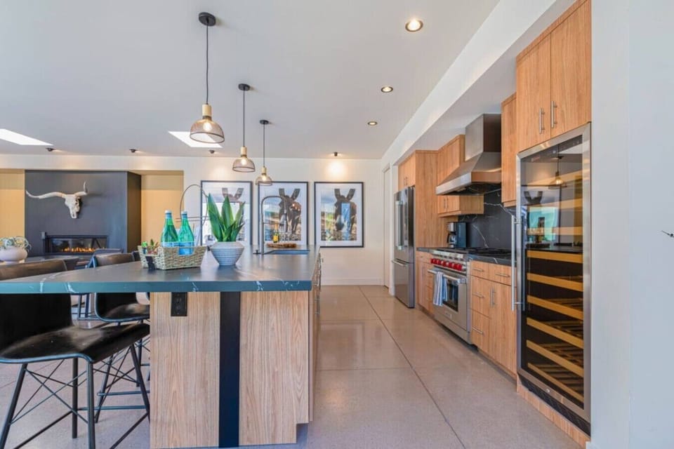 Kitchen w/ pendant lighting, pro range, wine fridge & island seating for the whole group.