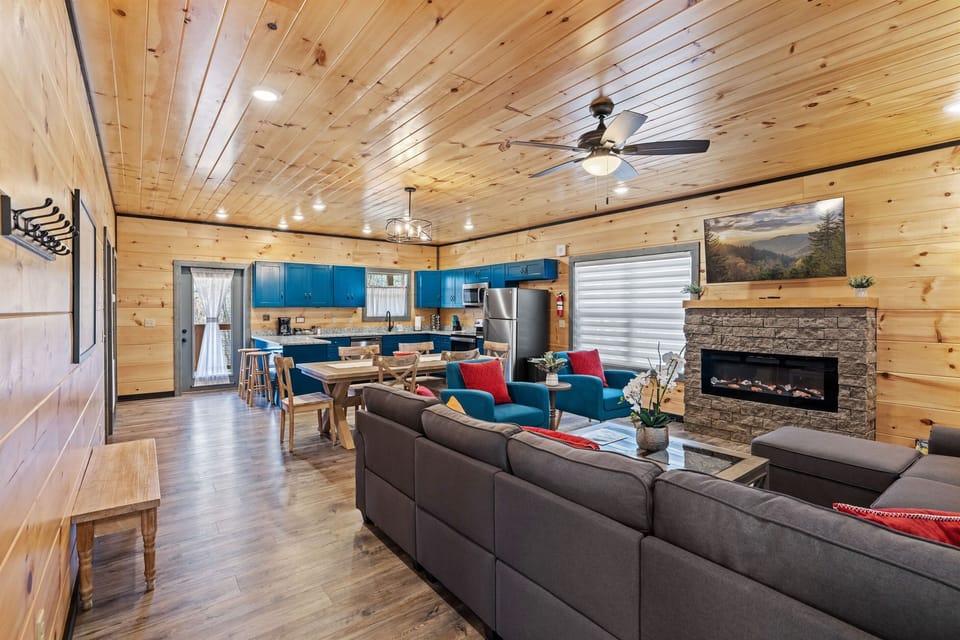 Open concept living room with large TV and electric fireplace.
