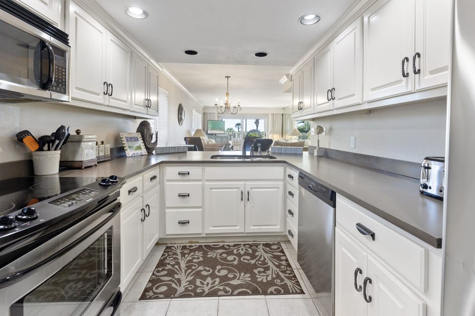 Your fully equipped kitchen welcomes culinary adventures with modern appliances, granite counters, and crisp white cabinetry.