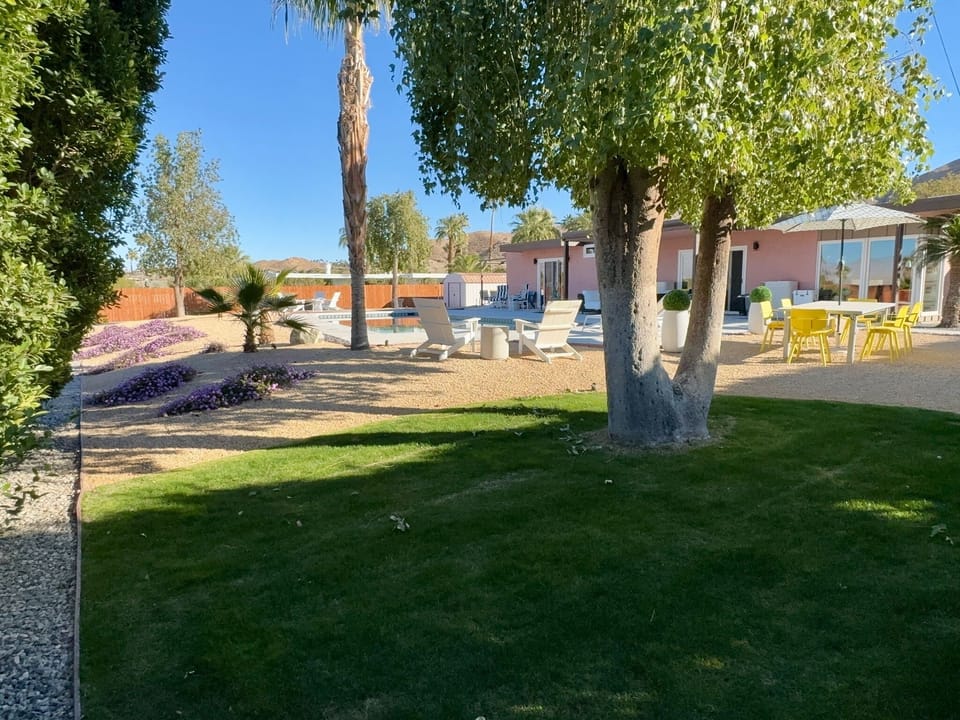 Expansive yard with resort-like landscaping and mature trees.