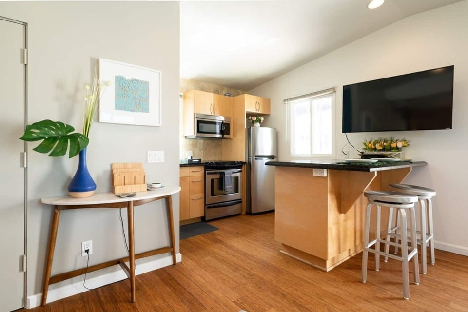 Across the room is the galley kitchen area with luxury marble countertops, stainless steel appliances.