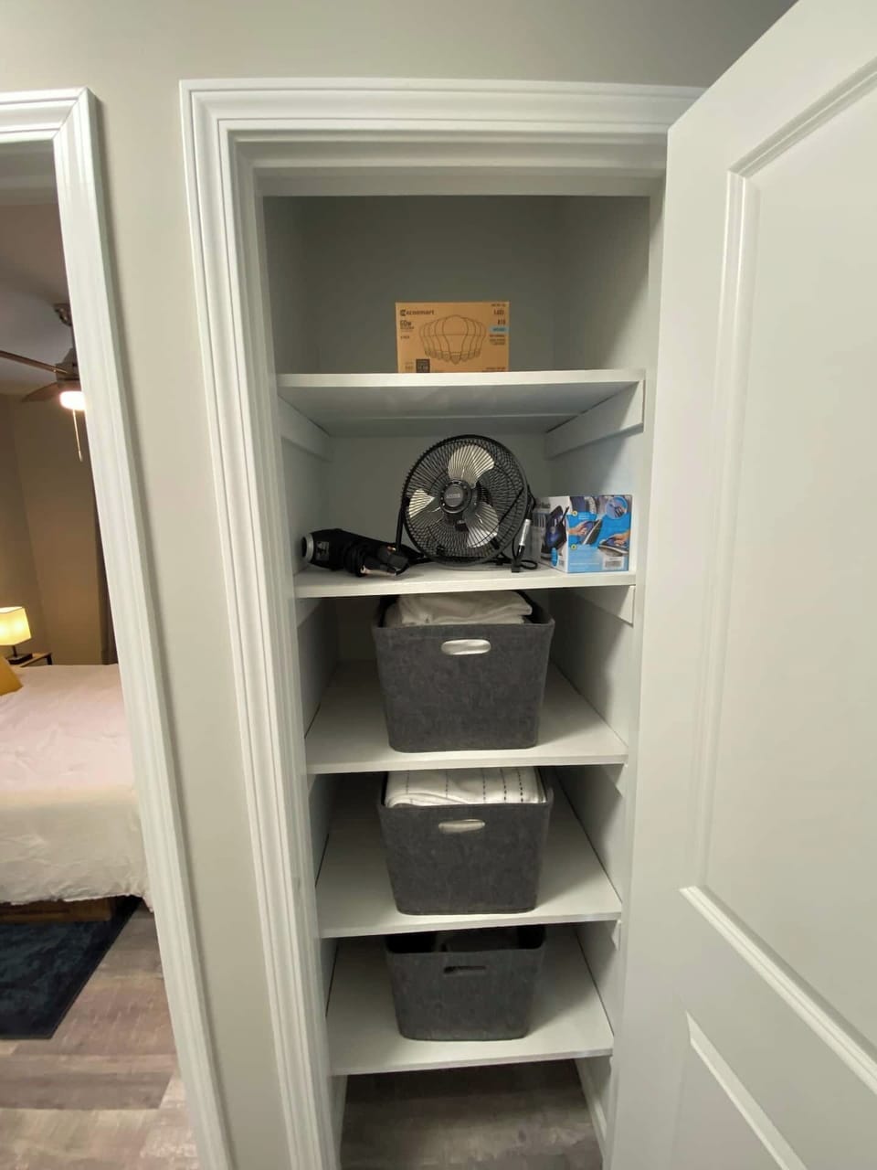Linen cabinet with towels, wash clothes, a fan, hair dryer, an iron, and extra light bulbs just in case. 