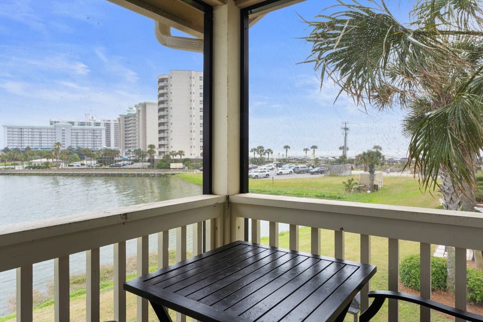 Enjoy serene lake and partial Gulf views from this cozy screened balcony, complete with a bistro table—ideal for relaxing in the coastal breeze.