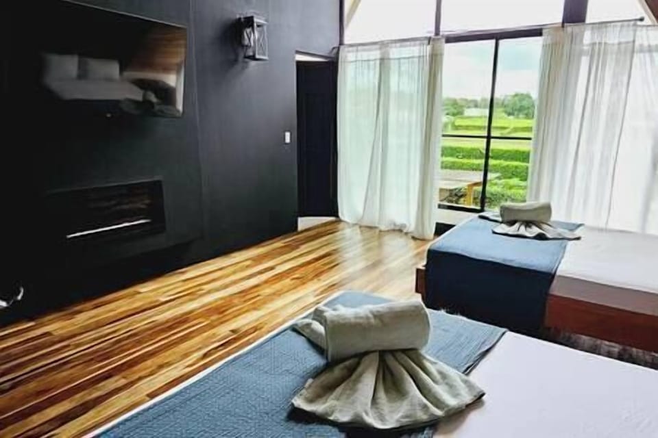 Pool view bedroom: beds beside the tall windows and wall-mounted TV.